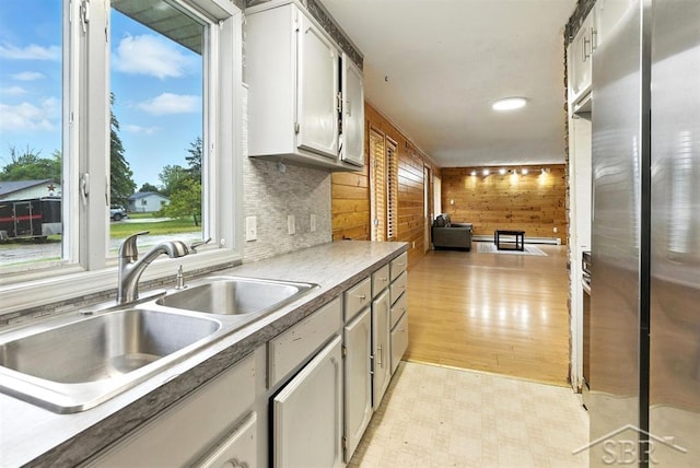 534 S Main St, Au Gres, MI 48703 - kitchen with light floors, freestanding refrigerator, wood walls, and white cabinets