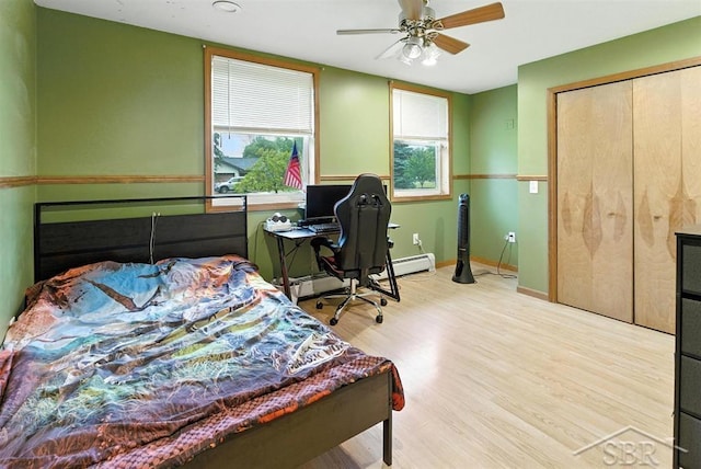 534 S Main St, Au Gres, MI 48703 - bedroom featuring wood finished floors, a closet, a ceiling fan, a baseboard radiator, and a desk