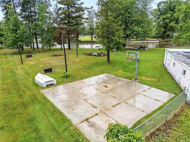 534 S Main St, Au Gres, MI 48703 - view of patio featuring a water view, basketball hoop, and view of scattered trees