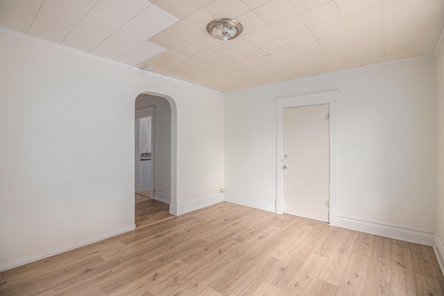 811 Larned St, Lansing, MI 48912 - spare room featuring arched walkways, light wood finished floors, and ornamental molding