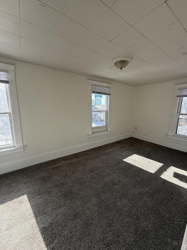 811 Larned St, Lansing, MI 48912 - unfurnished room with healthy amount of natural light, dark colored carpet, and a drop ceiling