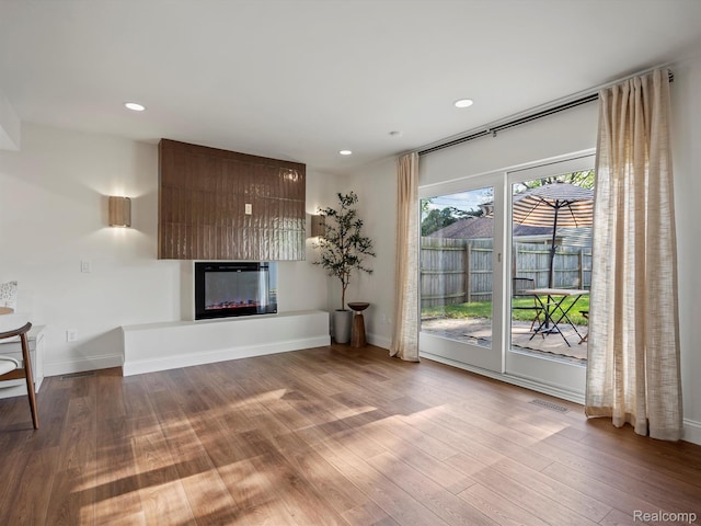 3025 Clawson Ave, Royal Oak, MI 48073 - unfurnished living room with wood finished floors, a glass covered fireplace, and recessed lighting