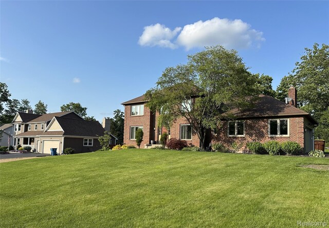 472 Ashton Ct SE, Grand Rapids, MI 49546 - view of front of house with brick siding, a front lawn, asphalt driveway, and a chimney