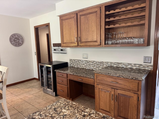 472 Ashton Ct SE, Grand Rapids, MI 49546 - kitchen featuring wine cooler, brown cabinetry, dark stone counters, light tile patterned flooring, and open shelves