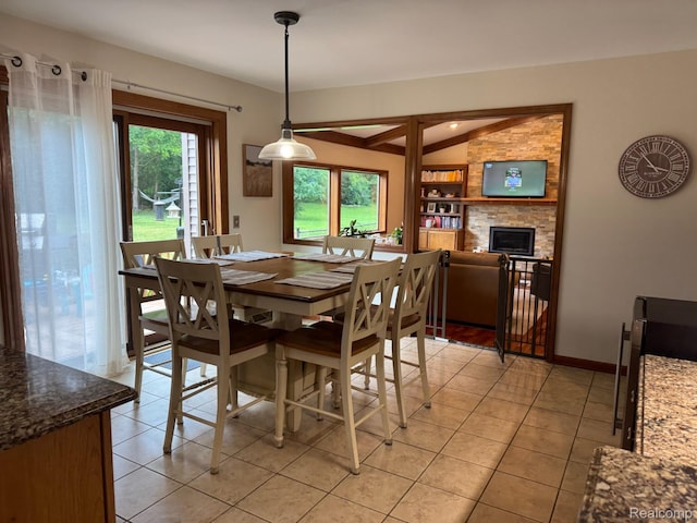 472 Ashton Ct SE, Grand Rapids, MI 49546 - dining room with light tile patterned floors, lofted ceiling, and a stone fireplace