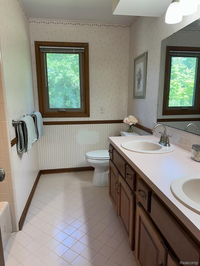 472 Ashton Ct SE, Grand Rapids, MI 49546 - full bathroom with double vanity, a bathtub, wallpapered walls, and tile patterned floors