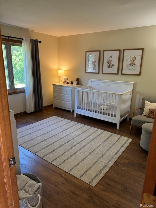 472 Ashton Ct SE, Grand Rapids, MI 49546 - bedroom with dark wood-style floors and a crib