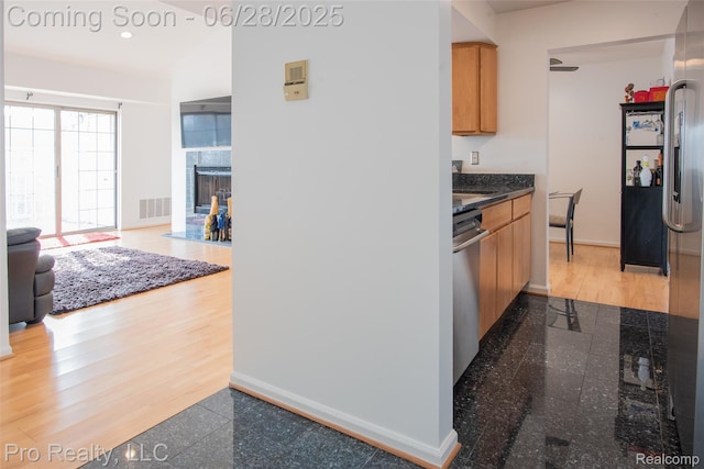 3559 Port Cove Dr Unit 25, Waterford, MI 48328 - kitchen featuring granite tiled floors, stainless steel appliances, a fireplace with flush hearth, open floor plan, and recessed lighting
