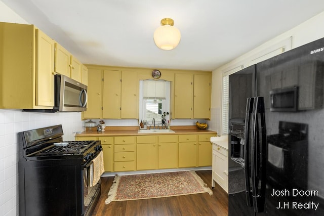 1802 Cherry St, Dorr, MI 49323 - kitchen with black appliances, dark wood-type flooring, light countertops, and decorative backsplash