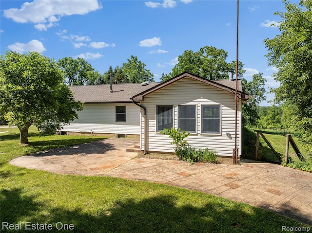 3225 W Marr Rd, Howell, MI 48855 - back of house featuring a patio, a lawn, roof with shingles, and a chimney