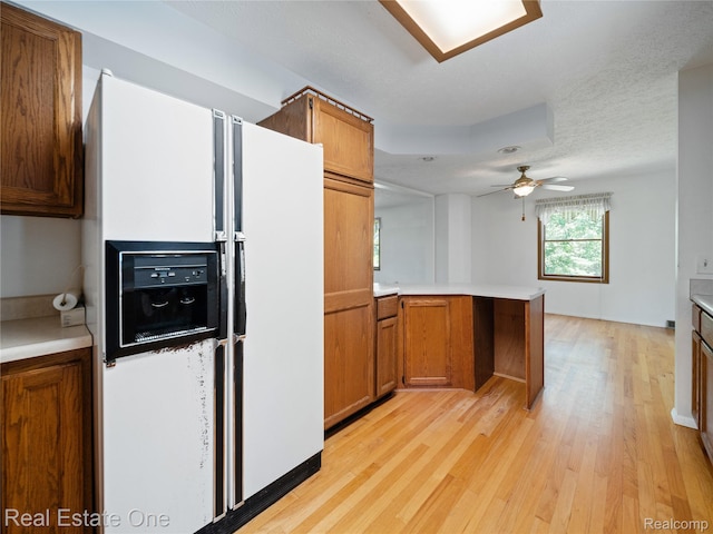 3225 W Marr Rd, Howell, MI 48855 - kitchen with white fridge with ice dispenser, a peninsula, light wood-style floors, and brown cabinetry