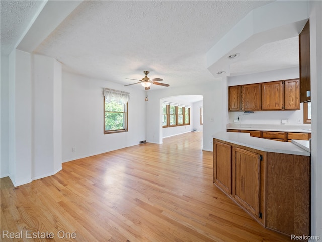 3225 W Marr Rd, Howell, MI 48855 - kitchen featuring a textured ceiling, light countertops, open floor plan, light wood-type flooring, and ceiling fan