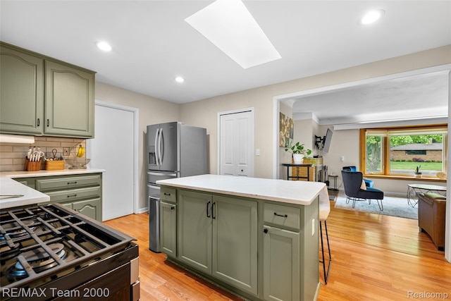 30695 Lyndon St, Livonia, MI 48154 - kitchen featuring green cabinets, gas range oven, light countertops, backsplash, and recessed lighting