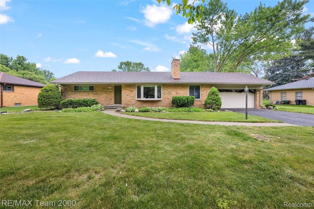 30695 Lyndon St, Livonia, MI 48154 - ranch-style home featuring asphalt driveway, a garage, a chimney, brick siding, and a front lawn