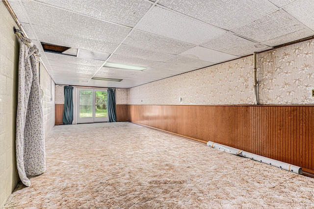 356 Riverview Dr, Plainwell, MI 49080 - empty room featuring carpet, a wainscoted wall, a drop ceiling, and wood walls