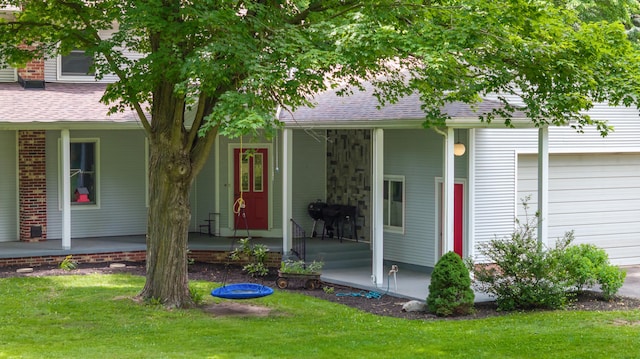 9719 King Rd, Spring Arbor, MI 49283 - view of exterior entry featuring a porch, an attached garage, a lawn, and roof with shingles