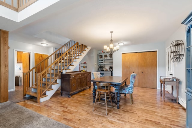 9719 King Rd, Spring Arbor, MI 49283 - dining space with stairway, a chandelier, and light wood-type flooring