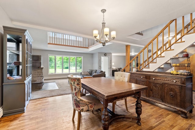 9719 King Rd, Spring Arbor, MI 49283 - dining area featuring a chandelier, stairs, light wood finished floors, and a raised ceiling