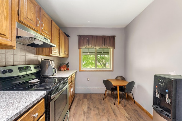 9719 King Rd, Spring Arbor, MI 49283 - kitchen featuring electric range, under cabinet range hood, a baseboard radiator, backsplash, and wood finished floors