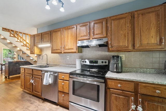 9719 King Rd, Spring Arbor, MI 49283 - kitchen with stainless steel appliances, under cabinet range hood, and brown cabinetry