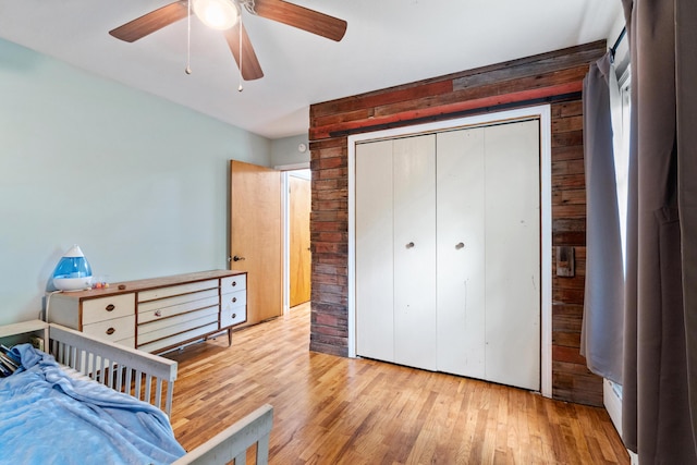 9719 King Rd, Spring Arbor, MI 49283 - bedroom featuring wooden walls, hardwood / wood-style floors, a closet, and ceiling fan