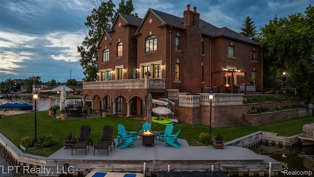 328 S Broadway St, Lake Orion, MI 48362 - back of house with an outdoor fire pit, brick siding, a yard, a chimney, and a deck with water view