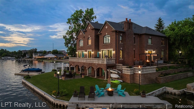 328 S Broadway St, Lake Orion, MI 48362 - back of property with an outdoor fire pit, a patio, a water view, a yard, and a chimney
