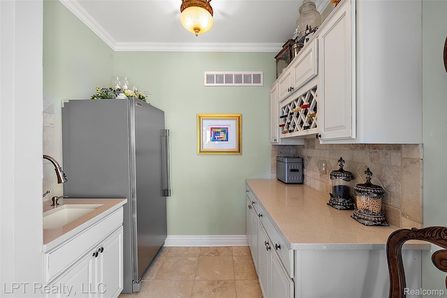 328 S Broadway St, Lake Orion, MI 48362 - kitchen featuring freestanding refrigerator, backsplash, crown molding, white cabinets, and light tile patterned floors