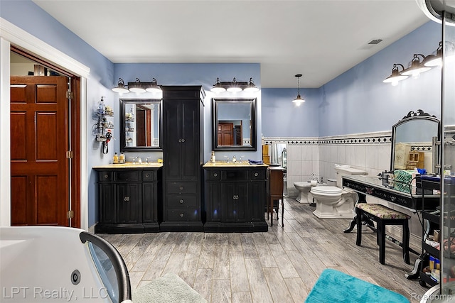 328 S Broadway St, Lake Orion, MI 48362 - full bathroom with a bidet, vanity, wood finished floors, a bath, and wainscoting