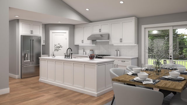 2862 Jade Ln, Traverse City, MI 49684 - kitchen with high end refrigerator, under cabinet range hood, light countertops, backsplash, and light wood-style floors