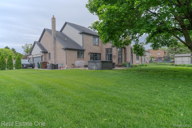 14607 Stratford, Shelby Twp, MI 48315 - rear view of property featuring a hot tub, brick siding, a chimney, and a garage