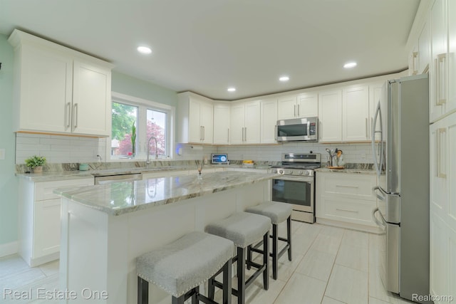 14607 Stratford, Shelby Twp, MI 48315 - kitchen with stainless steel appliances, decorative backsplash, a breakfast bar, a center island, and recessed lighting