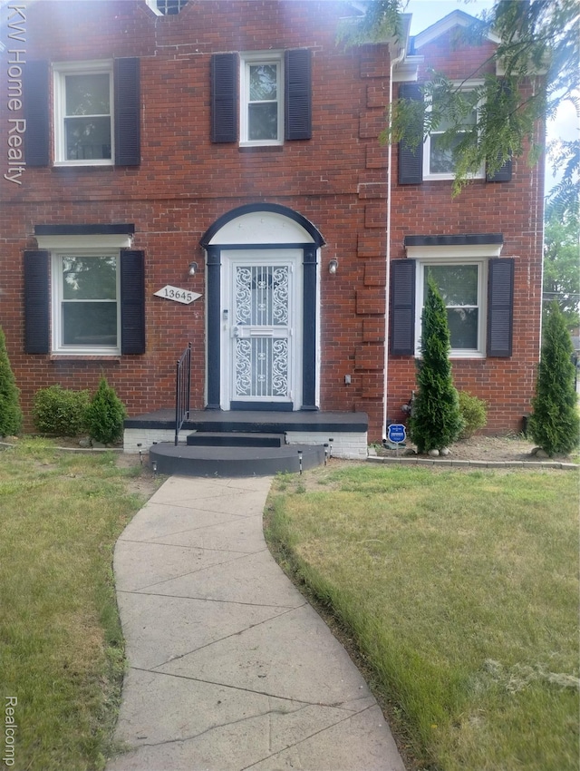 13645 Vassar Ave, Detroit, MI 48235 - doorway to property with brick siding and a lawn