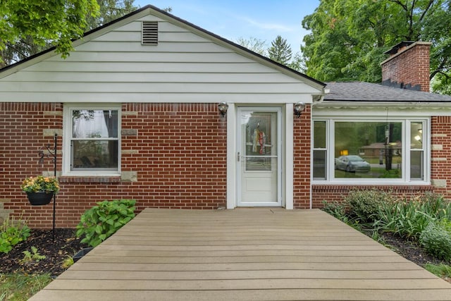 437 Collindale Ave NW, Grand Rapids, MI 49504 - view of front facade featuring a deck, brick siding, and a chimney