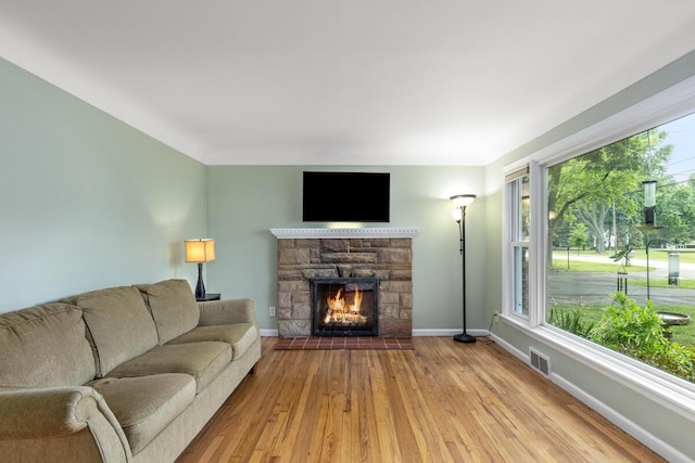 437 Collindale Ave NW, Grand Rapids, MI 49504 - living area featuring hardwood / wood-style flooring, a stone fireplace, and plenty of natural light