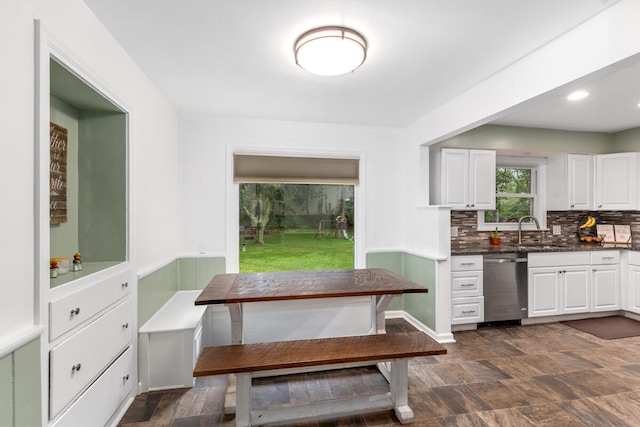 437 Collindale Ave NW, Grand Rapids, MI 49504 - kitchen featuring stainless steel dishwasher, white cabinets, backsplash, and stone finish flooring