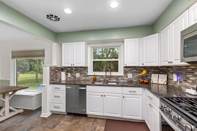 437 Collindale Ave NW, Grand Rapids, MI 49504 - kitchen with stainless steel appliances, white cabinets, dark stone countertops, backsplash, and recessed lighting