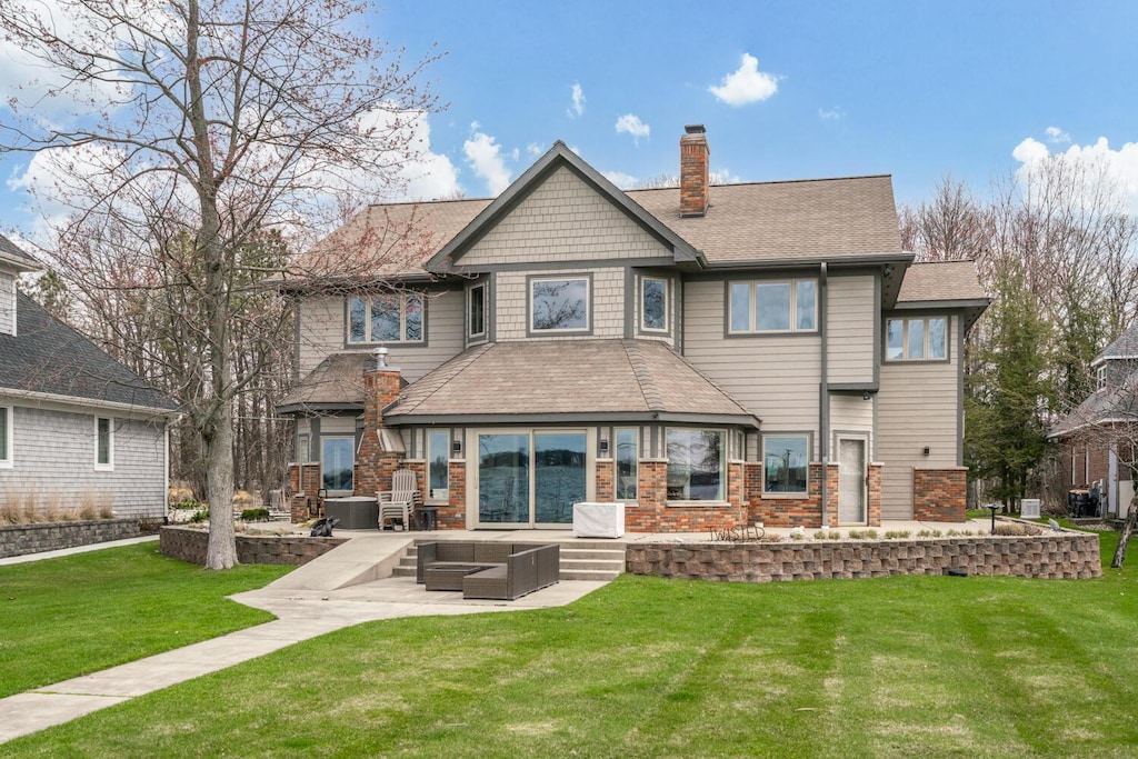 9230 E Shore Dr, Portage, MI 49002 - rear view of property featuring outdoor lounge area, a chimney, a patio, a yard, and brick siding