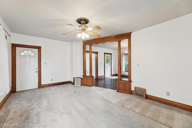 1 Grand Blvd, Battle Creek, MI 49015 - unfurnished living room featuring light colored carpet, healthy amount of natural light, a textured ceiling, and a ceiling fan