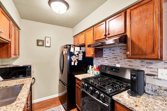 2220 Orchard Crest St, Shelby Twp, MI 48317 - kitchen featuring gas range, under cabinet range hood, stainless steel microwave, tasteful backsplash, and light stone countertops