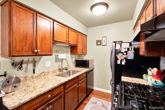 2220 Orchard Crest St, Shelby Twp, MI 48317 - kitchen with stainless steel microwave, dishwashing machine, light wood finished floors, light stone counters, and brown cabinetry