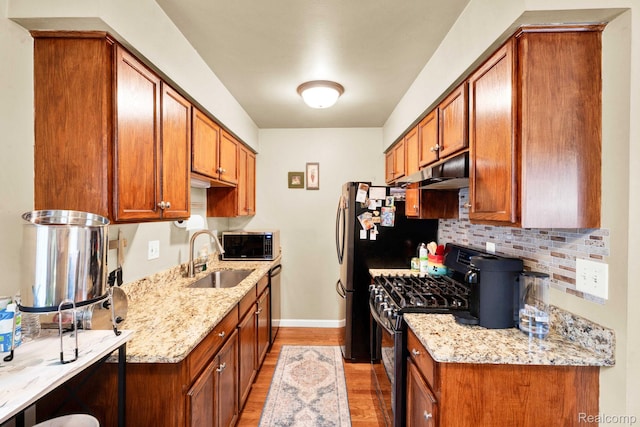 2220 Orchard Crest St, Shelby Twp, MI 48317 - kitchen featuring stainless steel appliances, under cabinet range hood, light wood finished floors, decorative backsplash, and brown cabinetry