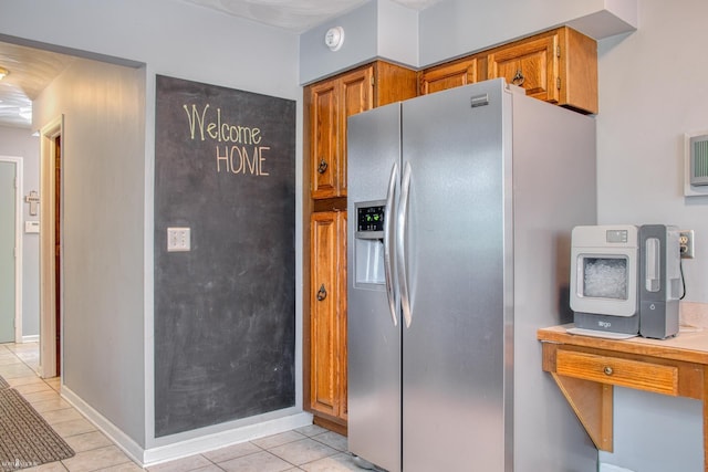 279 Ardelean Dr, Owosso, MI 48867 - kitchen with stainless steel fridge, brown cabinetry, light tile patterned floors, and light countertops