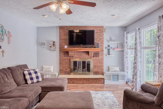 279 Ardelean Dr, Owosso, MI 48867 - living area with a ceiling fan, wood finished floors, a brick fireplace, and a textured ceiling