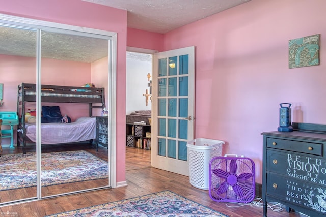 279 Ardelean Dr, Owosso, MI 48867 - bedroom with wood finished floors, a closet, and a textured ceiling