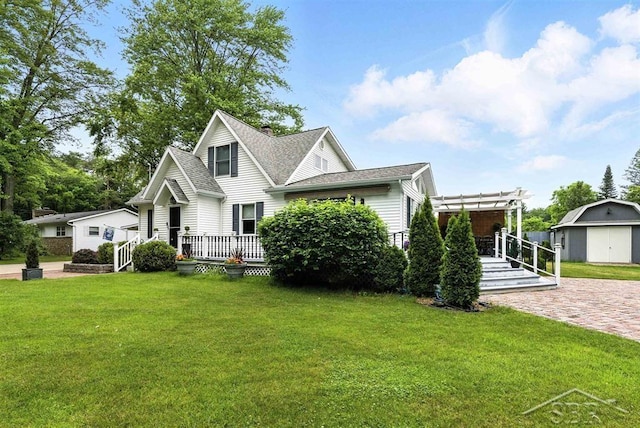 2816 Chippewa Ln, Midland, MI 48640 - view of front of home with a front lawn, a deck, a pergola, a shed, and a shingled roof