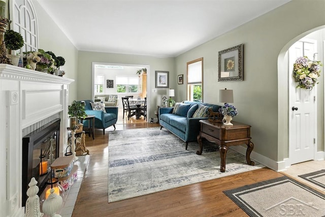 2816 Chippewa Ln, Midland, MI 48640 - living room featuring arched walkways, a fireplace with flush hearth, and wood finished floors