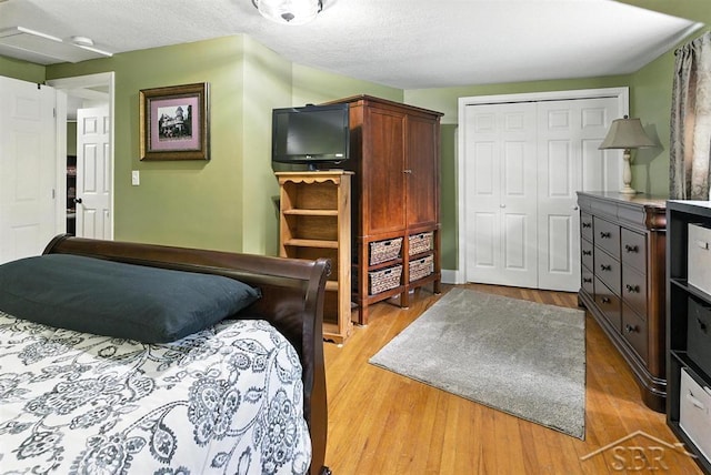 2816 Chippewa Ln, Midland, MI 48640 - bedroom featuring a closet, light wood-type flooring, and a textured ceiling
