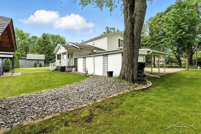 2816 Chippewa Ln, Midland, MI 48640 - rear view of house with an outdoor structure, a lawn, a carport, and driveway