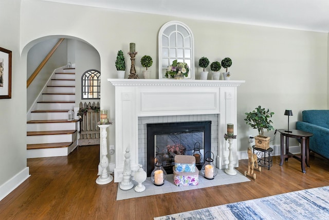 2816 Chippewa Ln, Midland, MI 48640 - living area featuring wood finished floors, stairway, and a brick fireplace